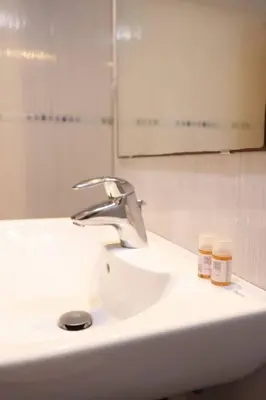 a bathroom sink with a faucet and two bottles on it at Piso en Betanzos in Betanzos