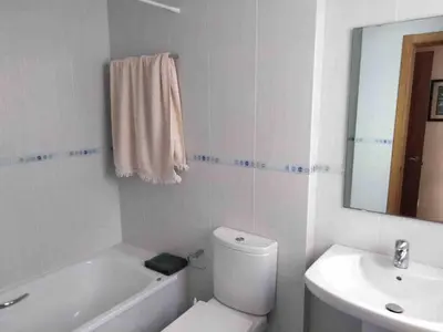 a white bathroom with a toilet and a sink at Piso en Betanzos in Betanzos