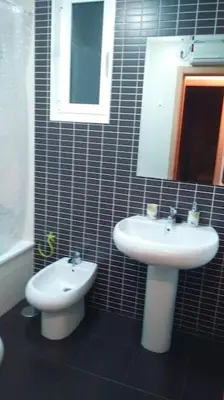 a bathroom with a sink and a toilet and a mirror at Piso Encanto Palmeiro in Jove