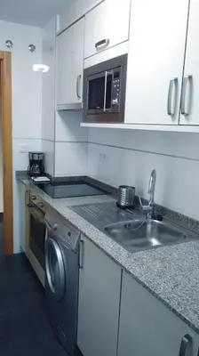 a kitchen with a sink and a washing machine at Piso Encanto Palmeiro in Jove