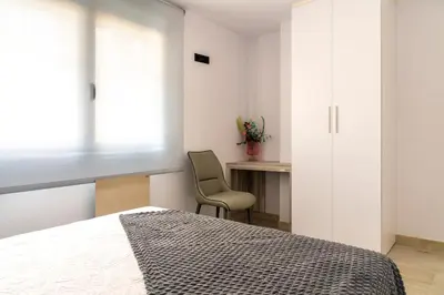 a bedroom with a bed and a chair and a desk at Maijo Burela Playa in Burela de Cabo