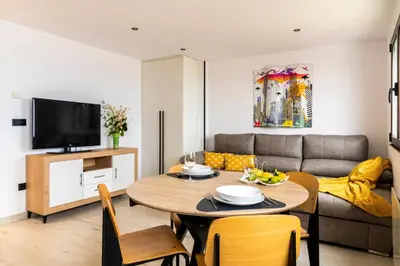a living room with a table and a couch at Maijo Burela Playa in Burela de Cabo