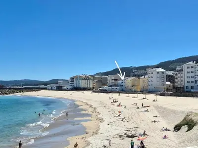 a group of people on a beach near the ocean at Maijo Burela Playa in Burela de Cabo