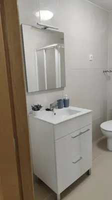 a white bathroom with a sink and a toilet at LAR de Yago - Habitación Ribadeo in Ribadeo