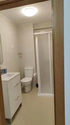 a bathroom with a toilet and a glass shower backdoor at LAR de Yago - Habitación Ribadeo in Ribadeo