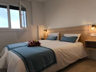 a bedroom with a large white bed with blue pillows at Luxury Singular Apartments Orange in Santiago de Compostela