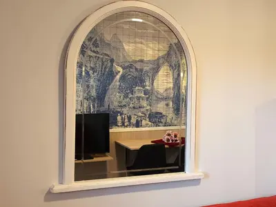 a room with a window with a tv on a wall at Luxury Singular Apartments Orange in Santiago de Compostela
