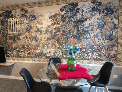 a dining room table with chairs and a large wall mural at Luxury Singular Apartments Orange in Santiago de Compostela