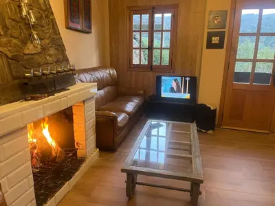 a living room with a couch and a fireplace at Casa A Boga RIBEIRA SACRA in Abeleda
