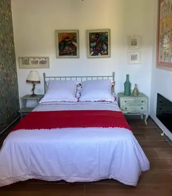 a bedroom with a large bed with a red and white bedspread at Casa A Boga RIBEIRA SACRA in Abeleda