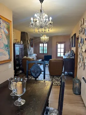 a living room with a table and a chandelier at Casa A Boga RIBEIRA SACRA in Abeleda
