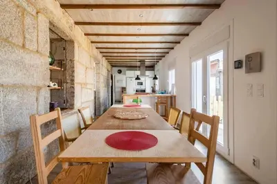 a dining room with a wooden table and chairs at Alojamiento rural en el centro de Galicia in Dozón
