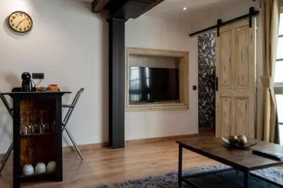 a living room with a tv and a table and a clock at Burgas1 in Ourense