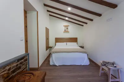 a bedroom with a bed in a white room at Apartamentos Rurales TIN TURISMO in Santa Eulalia de Oscos
