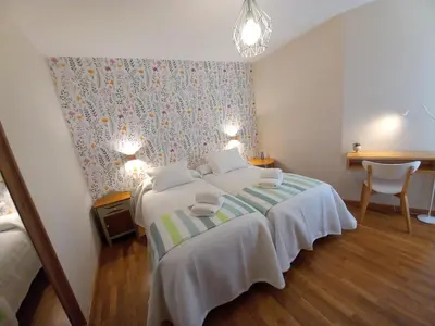 a bedroom with a bed and a table with a chair at Abrula Vilalba in Villalba