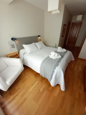 a bedroom with a large white bed with two towels on it at Abrula Vilalba in Villalba