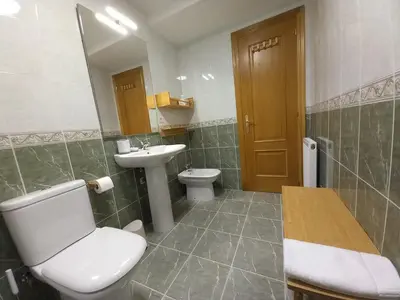 a bathroom with a white toilet and a sink at Abrula Vilalba in Villalba