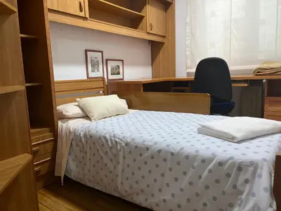 a bedroom with a bed and a desk and a chair at PISO ARTUR rúa astureses in Carballino