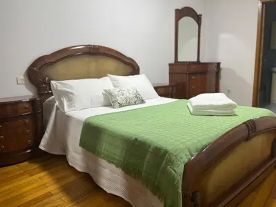 a bedroom with a large bed with a green blanket at PISO ARTUR rúa astureses in Carballino