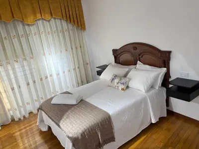 a bedroom with a large white bed and a window at PISO ARTUR rúa astureses in Carballino