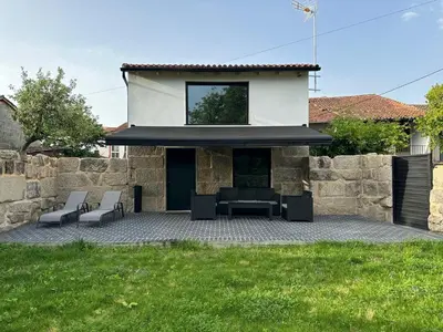 a patio with two chairs and a house at Casa Fernanda-Ribeira Sacra in Covas