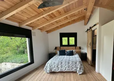 a bedroom with a bed and a large window at Casa Fernanda-Ribeira Sacra in Covas
