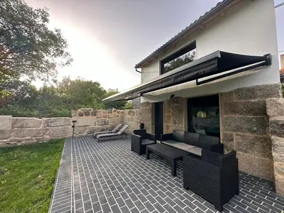 a patio with two benches and a building at Casa Fernanda-Ribeira Sacra in Covas