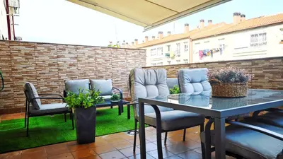a patio with chairs and a table and a brick wall at Piso céntrico Santiago de Compostela con terraza y parking in Santiago de Compostela