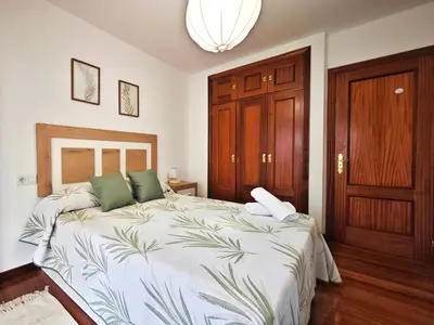 a bedroom with a large bed with green pillows at Piso céntrico Santiago de Compostela con terraza y parking in Santiago de Compostela