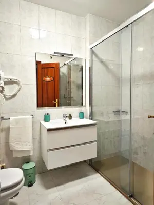 a bathroom with a sink and a glass shower at Piso céntrico Santiago de Compostela con terraza y parking in Santiago de Compostela