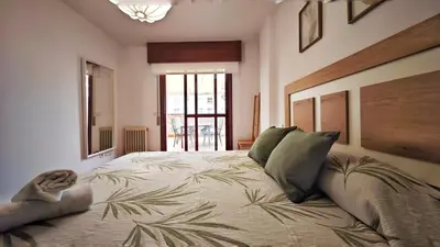 a bedroom with a large bed with green pillows at Piso céntrico Santiago de Compostela con terraza y parking in Santiago de Compostela
