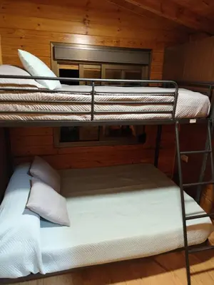 two bunk beds in a cabin with white sheets at Lar de Pazos in Padrón