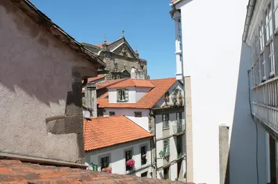 a group of buildings with red roofs on a street at Pensión con Encanto San Martiño Pinario in Santiago de Compostela