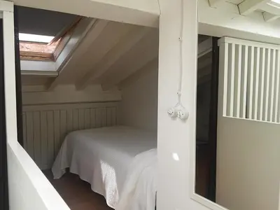 a small bedroom with a bed in a attic at Pensión con Encanto San Martiño Pinario in Santiago de Compostela