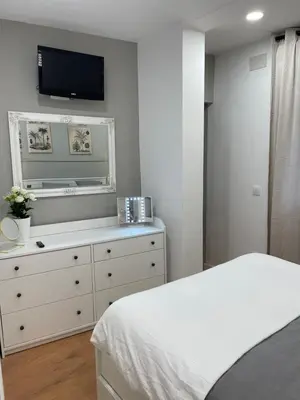 a bedroom with a bed and a dresser with a tv at Alojamiento D'Moda in Ribadeo