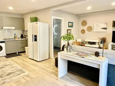 a kitchen with a white refrigerator and a table at Alojamiento D'Moda in Ribadeo