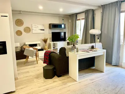 a living room with a couch and a desk in a room at Alojamiento D'Moda in Ribadeo