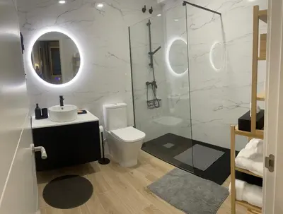 a bathroom with a toilet and a sink and a shower at Alojamiento D'Moda in Ribadeo