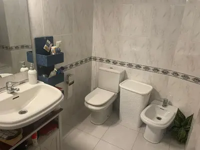 a white bathroom with a sink and a toilet at Apartamento Xaquina in Melide