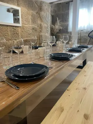 a long wooden table with glasses and plates on it at Casa de Lucinda-Ribeira Sacra in Covas