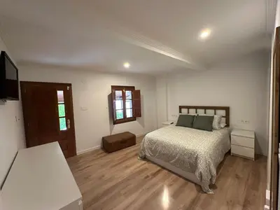a bedroom with a bed and a wooden floor at Casa de Lucinda-Ribeira Sacra in Covas