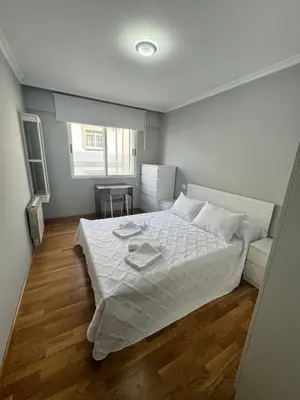 a bedroom with a white bed and a table at Serendipia in Villalba