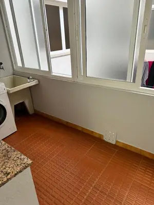 a bathroom with two windows and a orange tile floor at Serendipia in Villalba