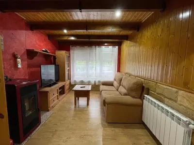 a living room with a couch and a tv at Apartamento La Veiga in Cerredo
