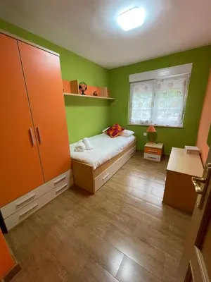 a green bedroom with a bed and a window at Apartamento La Veiga in Cerredo