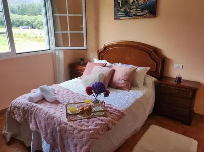 a bedroom with a bed with a tray with flowers on it at El Rincón Del Silencio in Moucide