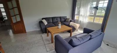 a living room with two blue couches and a table at El Rincón Del Silencio in Moucide