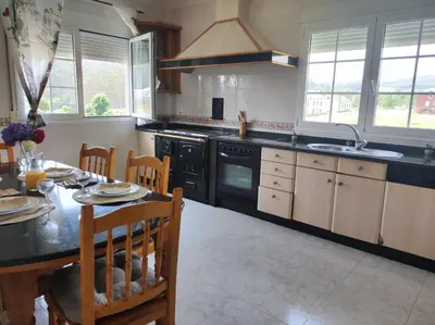 a kitchen with a table and a stove top oven at El Rincón Del Silencio in Moucide