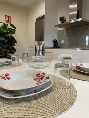a white table with a plate and glasses on it at Eira do Xastre in Brocos