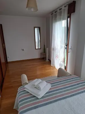 a bedroom with a bed with two towels on it at Piso DJC in O Pedrouzo